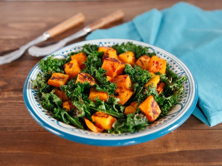 Nutrient-packed sweet potato and kale salad on a plate and a blue napkin