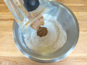 Adding pureed fruit from blender into dry ingredients.