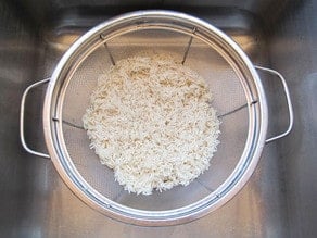 Rinsing rice in a colander.