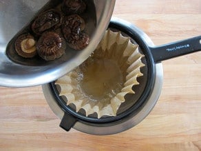 Straining broth from rehydrated mushrooms.