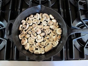 Sliced mushrooms in a skillet.