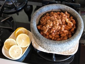 Mashing fava beans in a mixing bowl.