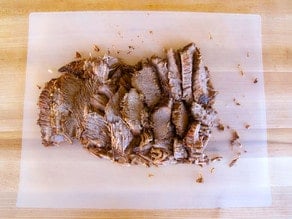 Brisket on a cutting board, sliced against the grain.