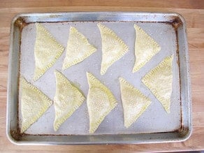 Bourekas on a parchment lined baking sheet.