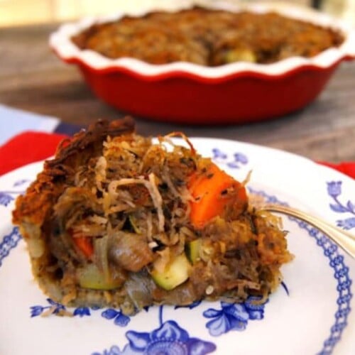 A savory potato pie with roasted vegetables, topped with a crispy potato crust