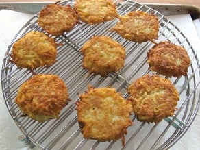 Potato latkes draining on a rack.