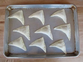 Bourekas on a greased baking sheet.