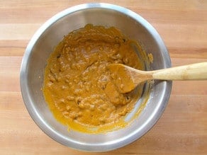 Raisins folded into cake batter in a bowl.