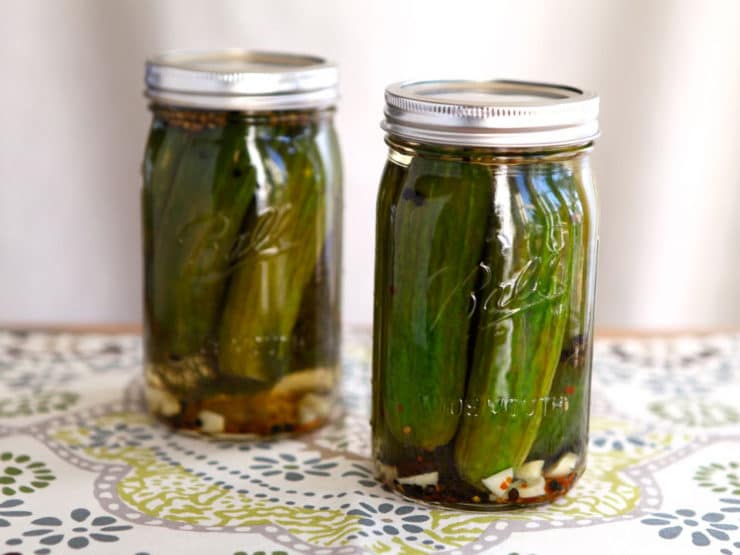 Two jars of pickles on a placemat.