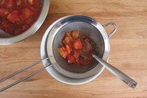 Pressing juice from tomato flesh.