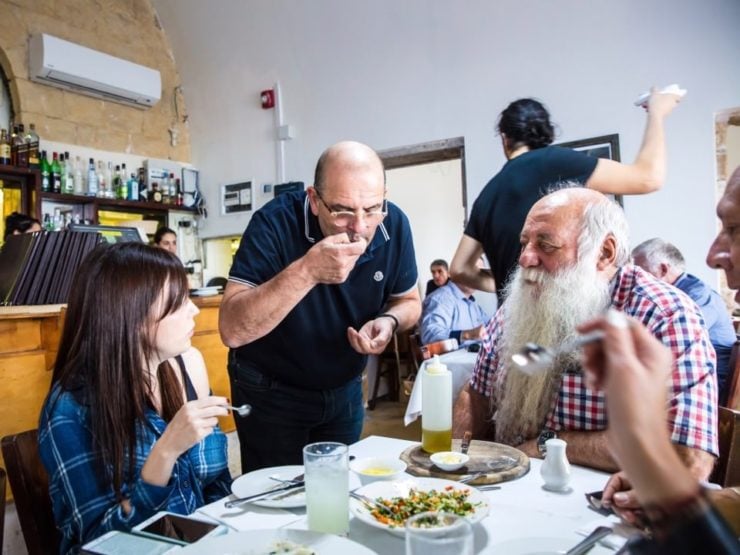 A group of people sitting at a restaurant table enjoying a meal.