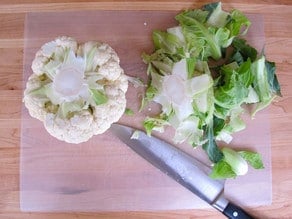 Cutting the stem off a head of cauliflower.