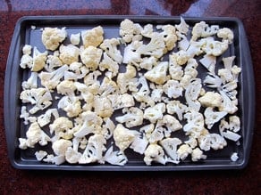 Cauliflower florets on a baking sheet.