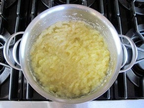 Sliced apples in water in a stockpot.