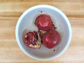 Pomegranate sections submerged in water.