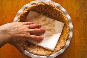 Blotting potato crust with paper towel.