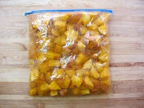 Seasoning added to potatoes in zipper top bag.