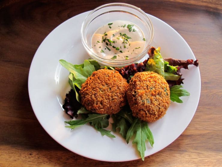 Overhead shot of Spicy Panko Chickpea Patties served on a white round plate on top of a wooden table