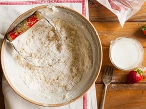 Using a pastry cutter to add butter to flour.