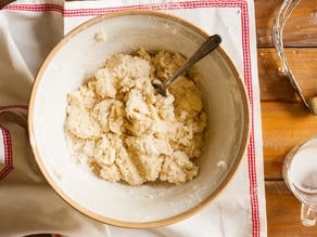 Stirring milk into biscuit dough.