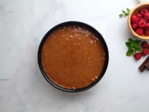 Overhead horizontal shot of a springform pan filled with chocolate almond flour cake batter.