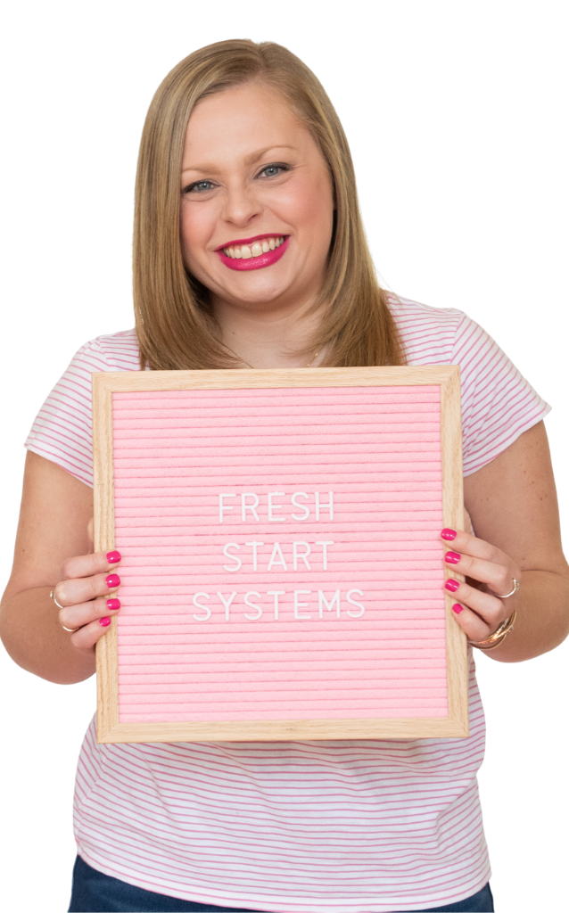 Alexandra of The Productivity Zone holding a pink letterboard with the words Fresh Start Systems spelled out on it.