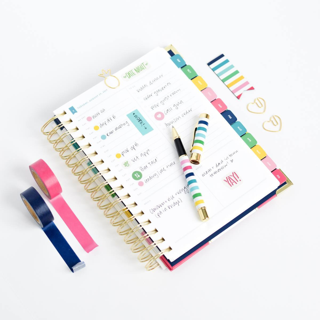 Simplified Planner folded over to show off a daily page using colorful planner accessories