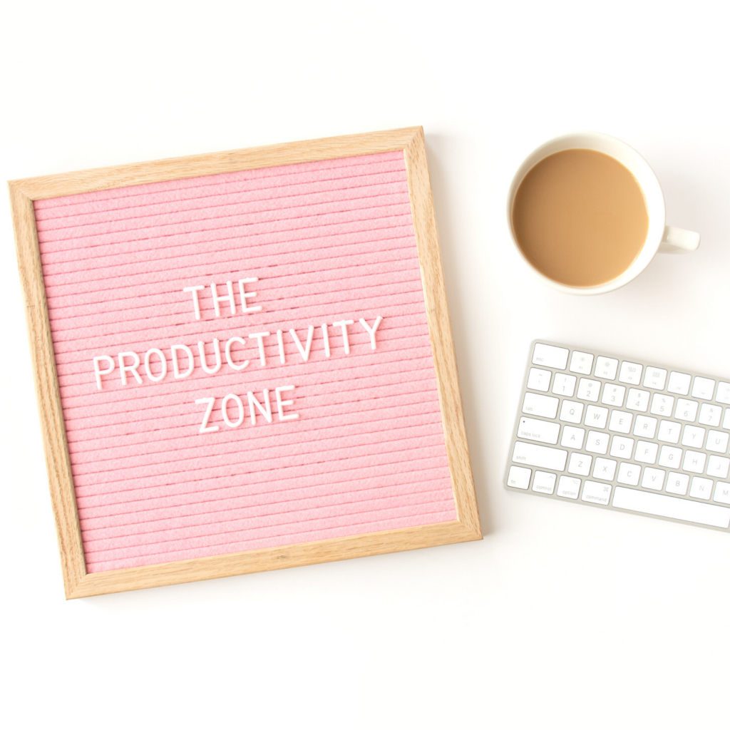 The Productivity Zone spelled out on pink letterboard with coffee cup and keyboard